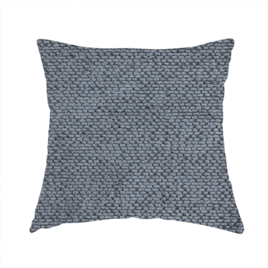 The fabric used to create this handmade cushion is a deep, moody charcoal or slate-grey upholstery fabric. It maintains the signature dense, uniform, boucle-style weave of the collection, composed of small, looped, and nubby yarn fibres that provide a soft and tactile surface.