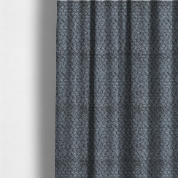 The fabric used to create these made-to-measure curtains is a deep, moody charcoal or slate-grey upholstery fabric. It maintains the signature dense, uniform, boucle-style weave of the collection, composed of small, looped, and nubby yarn fibres that provide a soft and tactile surface.