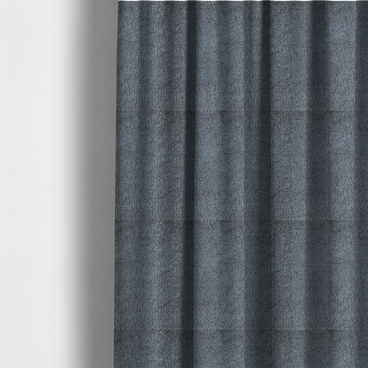 The fabric used to create these made-to-measure curtains is a deep, moody charcoal or slate-grey upholstery fabric. It maintains the signature dense, uniform, boucle-style weave of the collection, composed of small, looped, and nubby yarn fibres that provide a soft and tactile surface.