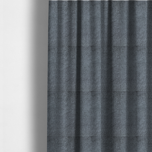 The fabric used to create these made-to-measure curtains is a deep, moody charcoal or slate-grey upholstery fabric. It maintains the signature dense, uniform, boucle-style weave of the collection, composed of small, looped, and nubby yarn fibres that provide a soft and tactile surface.