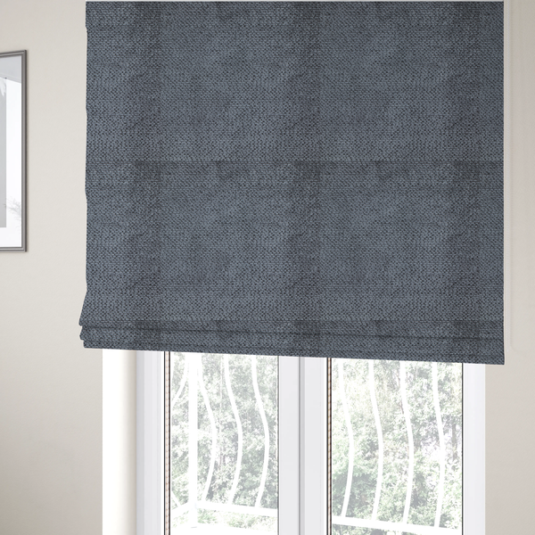 The fabric used to create these Roman blinds is a deep, moody charcoal or slate-grey upholstery fabric. It maintains the signature dense, uniform, boucle-style weave of the collection, composed of small, looped, and nubby yarn fibres that provide a soft and tactile surface.