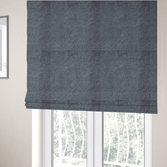 The fabric used to create these Roman blinds is a deep, moody charcoal or slate-grey upholstery fabric. It maintains the signature dense, uniform, boucle-style weave of the collection, composed of small, looped, and nubby yarn fibres that provide a soft and tactile surface.