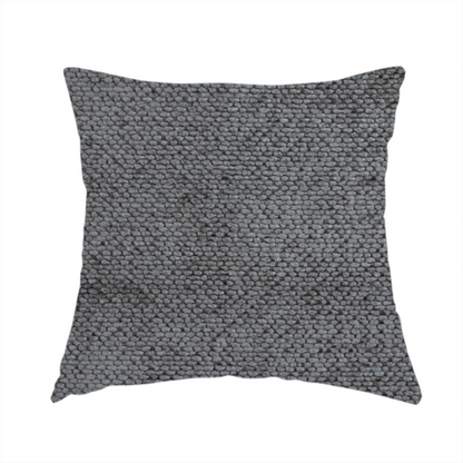 The fabric used to create this handmade cushion is a deep, dark grey or graphite-toned upholstery fabric. It features the signature dense, uniform, boucle-style weave of the collection, composed of small, looped, and nubby yarn fibres that create a soft and tactile surface.