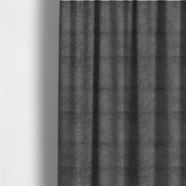 The fabric used to create these made-to-measure curtains is a deep, dark grey or graphite-toned upholstery fabric. It features the signature dense, uniform, boucle-style weave of the collection, composed of small, looped, and nubby yarn fibres that create a soft and tactile surface.