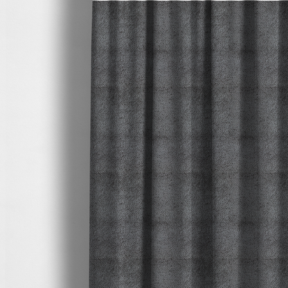The fabric used to create these made-to-measure curtains is a deep, dark grey or graphite-toned upholstery fabric. It features the signature dense, uniform, boucle-style weave of the collection, composed of small, looped, and nubby yarn fibres that create a soft and tactile surface.