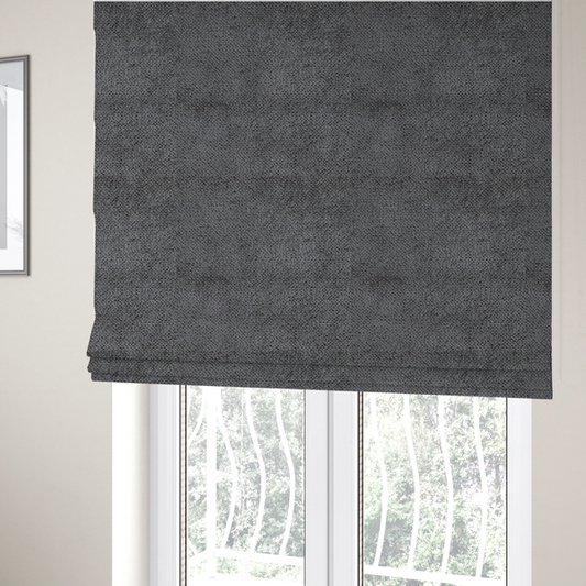The fabric used to create these Roman blinds is a deep, dark grey or graphite-toned upholstery fabric. It features the signature dense, uniform, boucle-style weave of the collection, composed of small, looped, and nubby yarn fibres that create a soft and tactile surface.