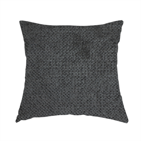 The fabric used to create this handmade cushion is a deep, dark charcoal or near-black upholstery fabric. It maintains the signature dense, uniform, boucle-style weave of the collection, characterized by small, looped, and nubby yarn fibres that provide a soft and tactile surface.