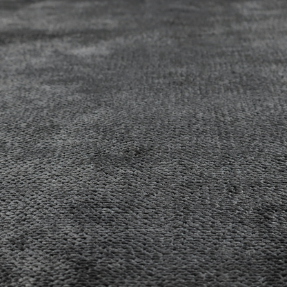 A deep, dark charcoal or near-black upholstery fabric. It maintains the signature dense, uniform, boucle-style weave of the collection, characterized by small, looped, and nubby yarn fibres that provide a soft and tactile surface.
