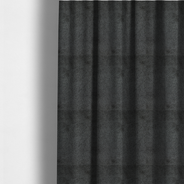 The fabric used to create these made-to-measure curtains is a deep, dark charcoal or near-black upholstery fabric. It maintains the signature dense, uniform, boucle-style weave of the collection, characterized by small, looped, and nubby yarn fibres that provide a soft and tactile surface.