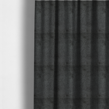 The fabric used to create these made-to-measure curtains is a deep, dark charcoal or near-black upholstery fabric. It maintains the signature dense, uniform, boucle-style weave of the collection, characterized by small, looped, and nubby yarn fibres that provide a soft and tactile surface.