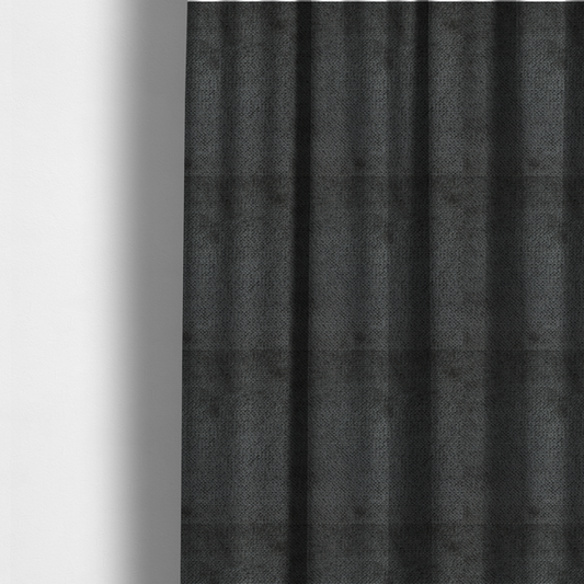 The fabric used to create these made-to-measure curtains is a deep, dark charcoal or near-black upholstery fabric. It maintains the signature dense, uniform, boucle-style weave of the collection, characterized by small, looped, and nubby yarn fibres that provide a soft and tactile surface.