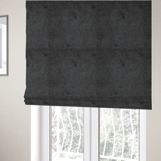 The fabric used to create these Roman blinds is a deep, dark charcoal or near-black upholstery fabric. It maintains the signature dense, uniform, boucle-style weave of the collection, characterized by small, looped, and nubby yarn fibres that provide a soft and tactile surface.