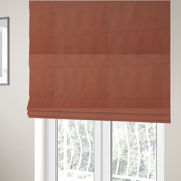 The fabric used to create these Roman blinds is a solid rust-coloured Hallstatt faux leather fabric texture with a smooth, fine finish.