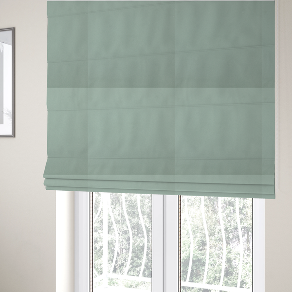 The fabric used to create these Roman blinds is a solid sage green-coloured Hallstatt faux leather fabric texture with a smooth, fine finish.