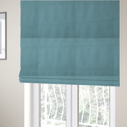 The fabric used to create these Roman blinds is a plain, solid blue-coloured Hallstatt faux leather fabric texture with a smooth, fine finish.