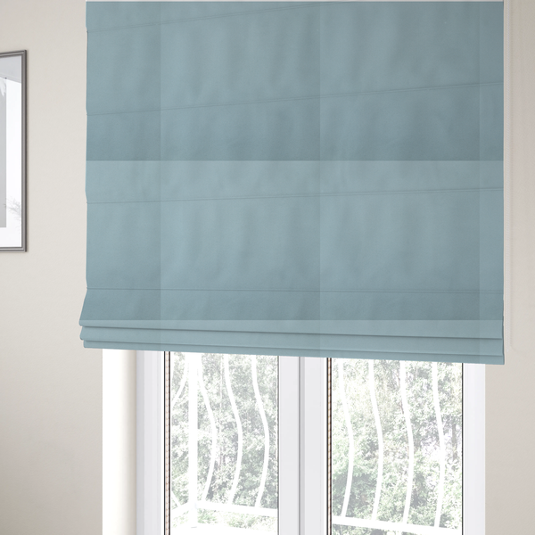 The fabric used to create these Roman blinds is a plain, solid light blue-coloured Hallstatt faux leather fabric texture with a smooth, fine finish.