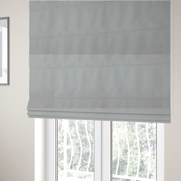 The fabric used to create these Roman blinds is a plain, solid light grey-coloured Hallstatt faux leather fabric texture with a smooth, fine finish.