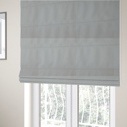 The fabric used to create these Roman blinds is a plain, solid light grey-coloured Hallstatt faux leather fabric texture with a smooth, fine finish.