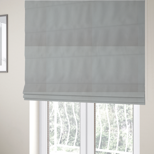The fabric used to create these Roman blinds is a plain, solid light grey-coloured Hallstatt faux leather fabric texture with a smooth, fine finish.