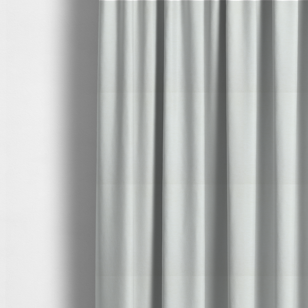 The fabric used to create these made-to-measure curtains is a solid light off-white or cream-coloured woven textile with a fine, subtle textured weave.