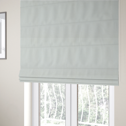 The fabric used to create these Roman blinds is a solid light off-white or cream-coloured woven textile with a fine, subtle textured weave.