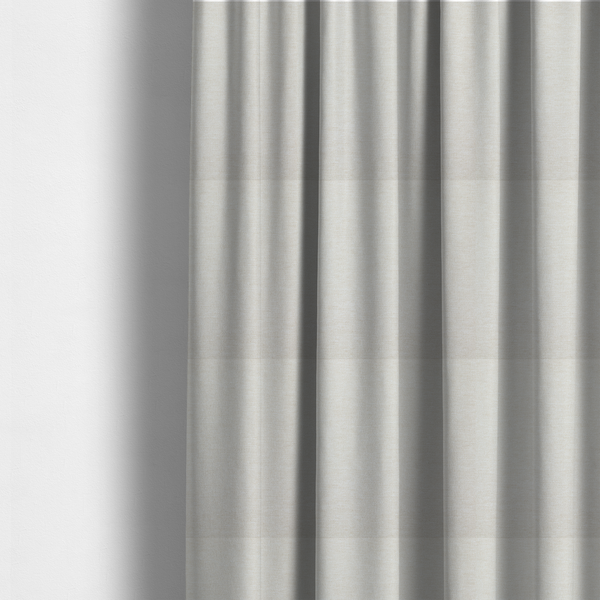 The fabric used to create these made-to-measure curtains is a solid light off-white or cream-coloured woven textile with a fine, subtle textured weave.