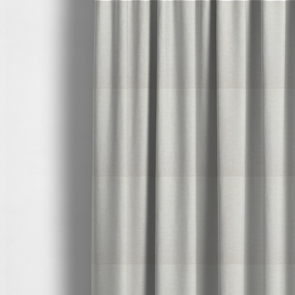 The fabric used to create these made-to-measure curtains is a solid light off-white or cream-coloured woven textile with a fine, subtle textured weave.