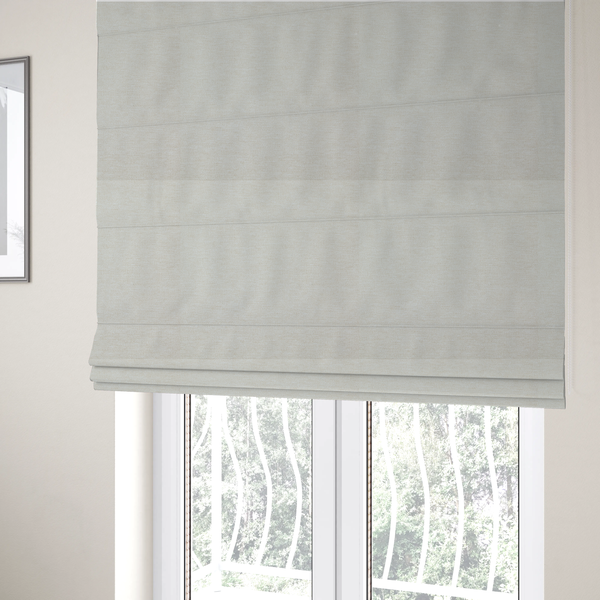 The fabric used to create these Roman blinds is a solid light off-white or cream-coloured woven textile with a fine, subtle textured weave.