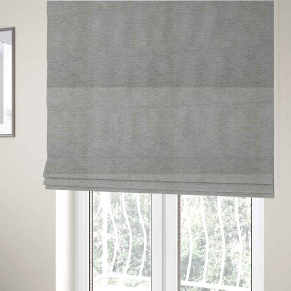 The fabric used to create these Roman blinds is a solid dark beige woven textile with a fine, subtle textured weave.