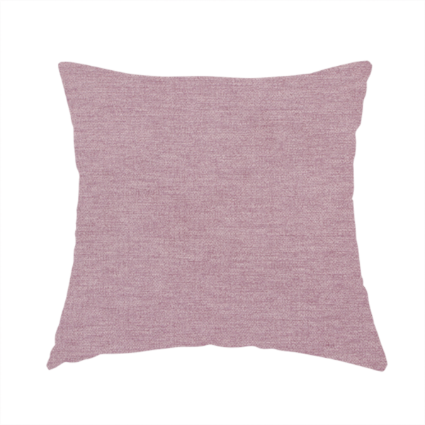 The fabric used to create this handmade cushion is a solid pink woven textile with a fine, subtle textured weave.