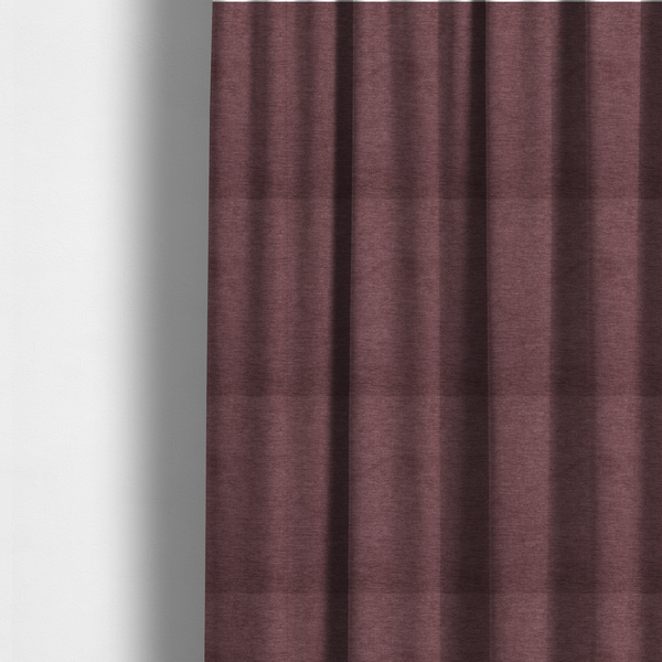 The fabric used to create these made-to-measure curtains is a solid dark pink or mauve woven textile with a fine, subtle textured weave.