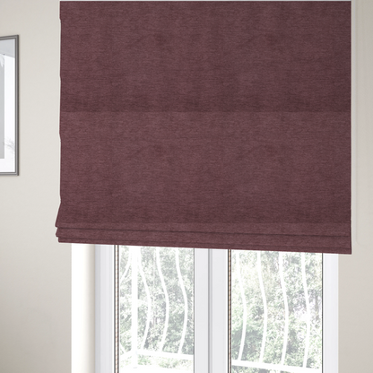 The fabric used to create these Roman blinds is a solid dark pink or mauve woven textile with a fine, subtle textured weave.