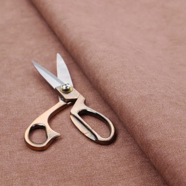 A solid muted pink or dusty rose woven textile with a fine, subtle textured weave.