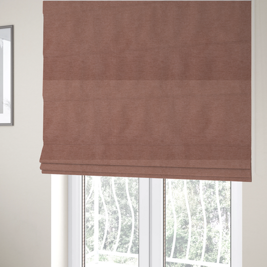 The fabric used to create these Roman blinds is a solid muted pink or dusty rose woven textile with a fine, subtle textured weave.