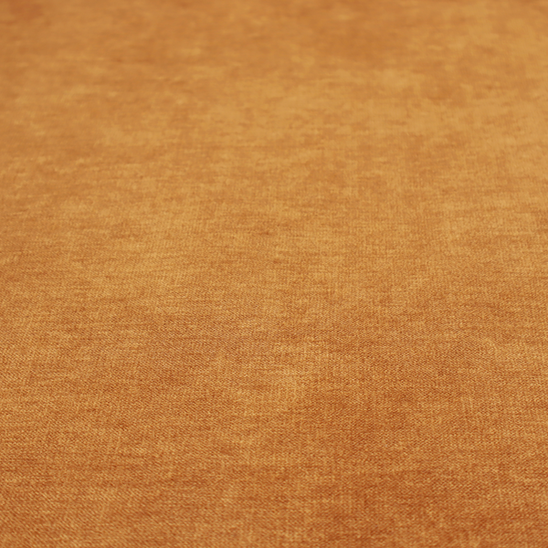 A solid orange or mustard yellow woven textile with a fine, subtle textured weave.