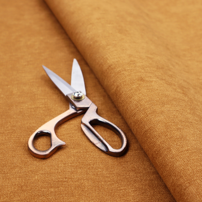 A solid orange or mustard yellow woven textile with a fine, subtle textured weave.