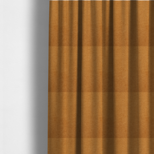 The fabric used to create these made-to-measure curtains is a solid orange or mustard yellow woven textile with a fine, subtle textured weave.