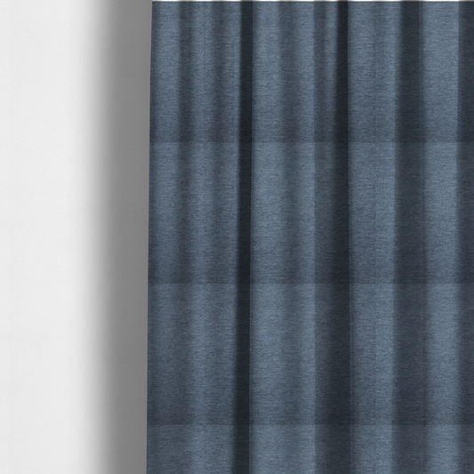 The fabric used to create these made-to-measure curtains is solid light blue or steel blue woven textile with a fine, subtle textured weave.