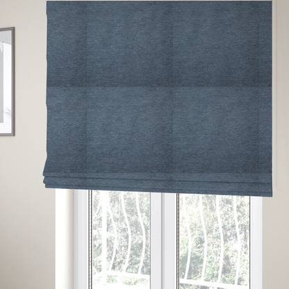 the fabric used to create these Roman blinds is a solid light blue or steel blue woven textile with a fine, subtle textured weave.