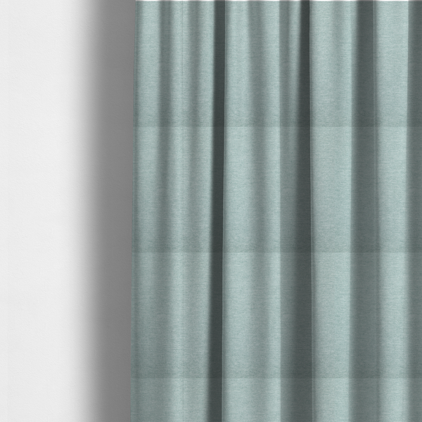 The fabric used to create these made-to-measure curtains is a solid pale aqua or mint green woven textile with a fine, subtle textured weave.