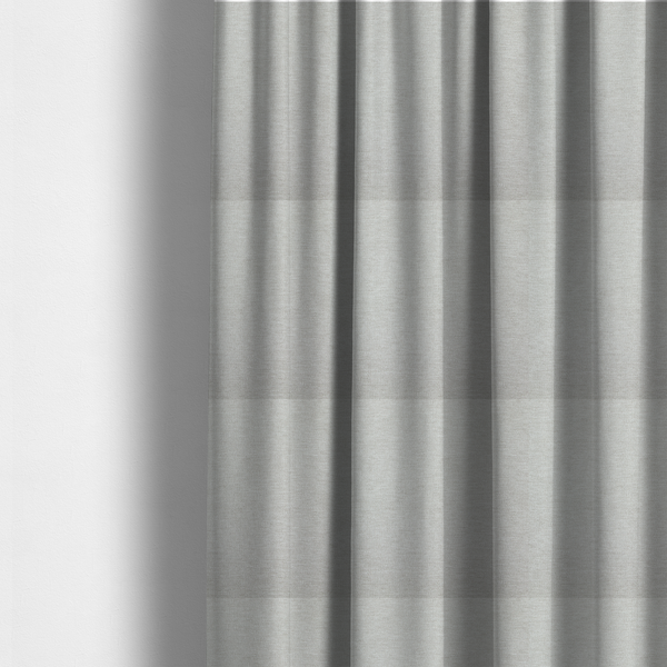 The fabric used to create these made-to-measure curtains is a light grey or silver woven textile with a fine, subtle textured weave.