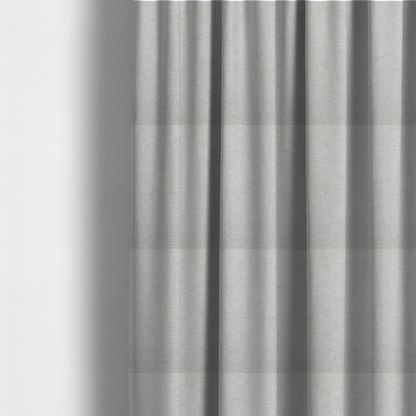 The fabric used to create these made-to-measure curtains is a light grey or silver woven textile with a fine, subtle textured weave.