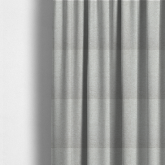 The fabric used to create these made-to-measure curtains is a light grey or silver woven textile with a fine, subtle textured weave.