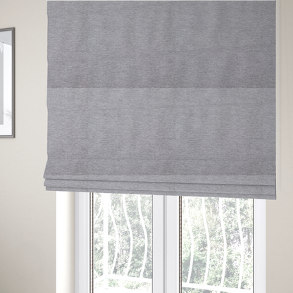 The fabric used to create these Roman blinds is a medium grey or silver-grey woven textile with a fine, subtle textured weave.