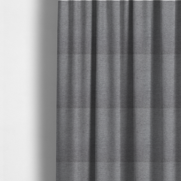The fabric used to create these made-to-measure curtains is a solid dark grey or charcoal woven textile with a fine, subtle textured weave.