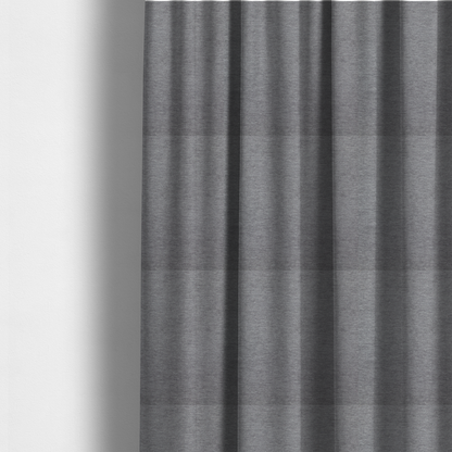The fabric used to create these made-to-measure curtains is a solid dark grey or charcoal woven textile with a fine, subtle textured weave.