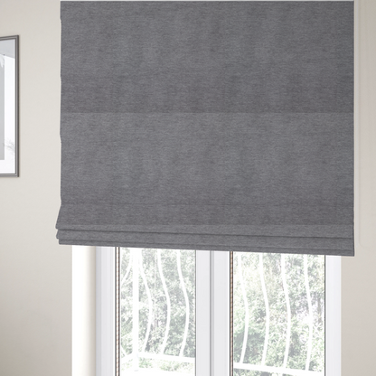 The fabric used to create these Roman blinds is a solid dark grey or charcoal woven textile with a fine, subtle textured weave.