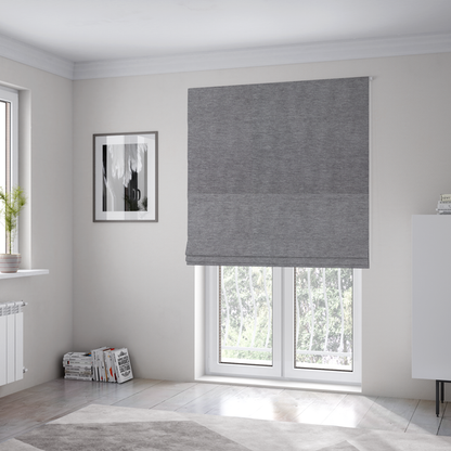 The fabric used to create these Roman blinds is a solid dark grey or charcoal woven textile with a fine, subtle textured weave.