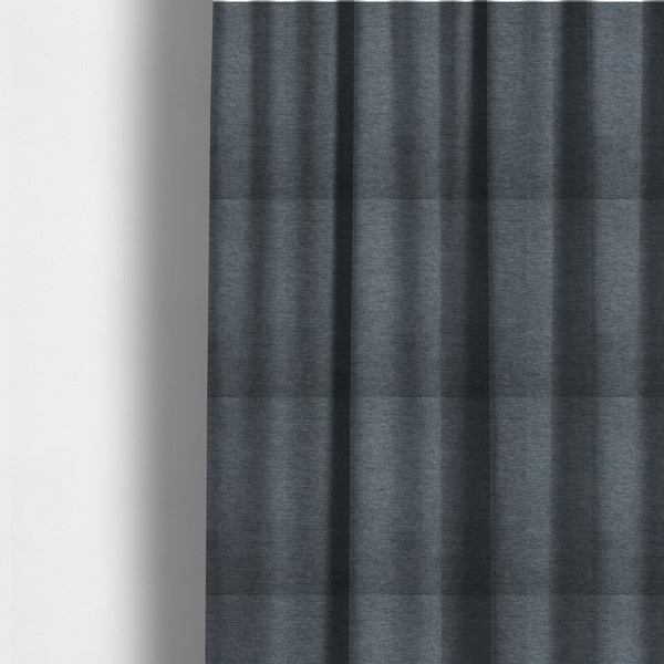 The fabric used to create these made-to-measure curtains is a solid dark denim blue or slate blue woven textile with a fine, subtle textured weave.