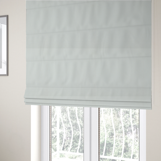 The fabric used to create these Roman blinds is a light grey or off-white fabric with a tight, fine weave texture.